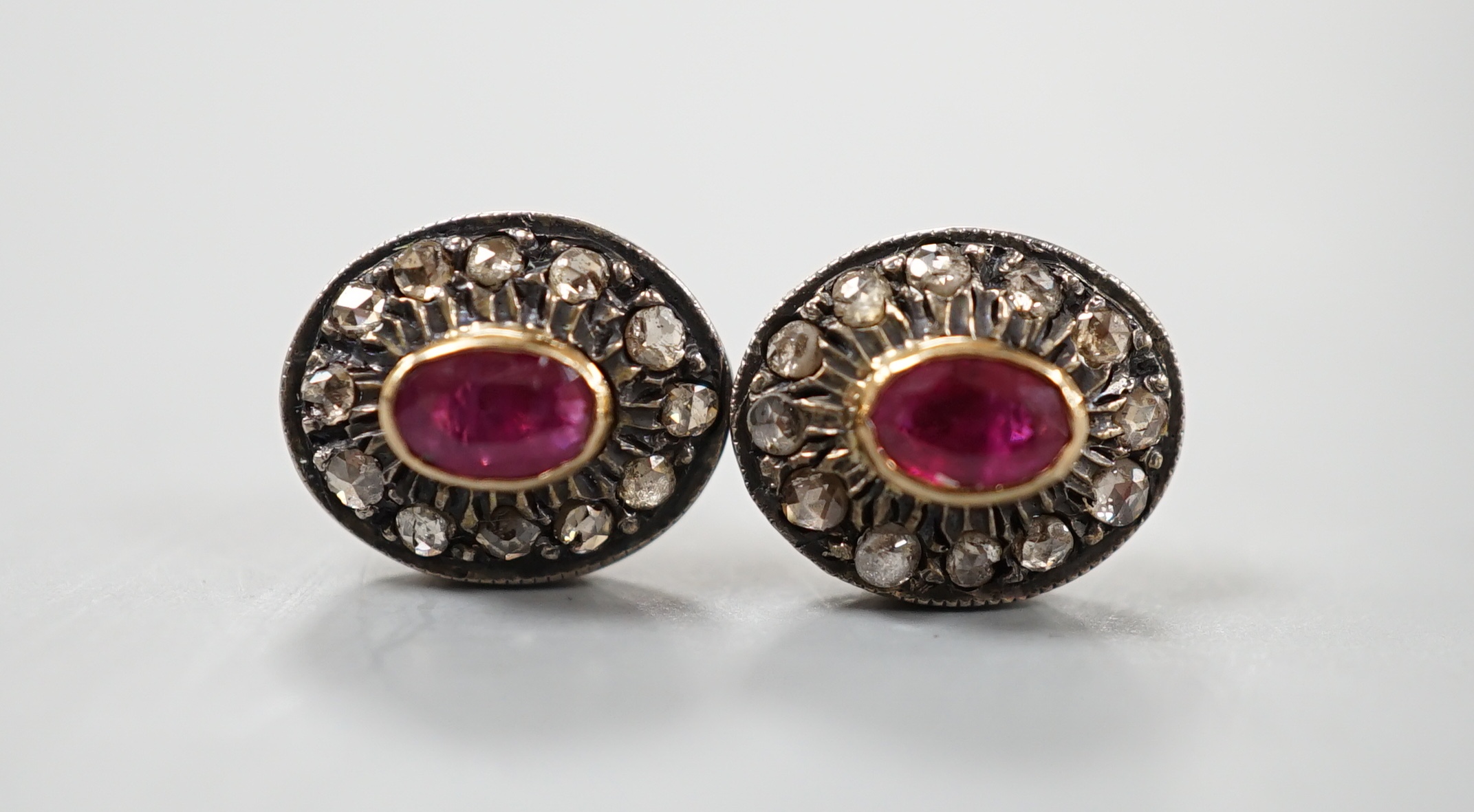A pair of yellow metal, ruby and rose cut diamond set oval cluster earrings, 10mm, gross 3.2 grams.